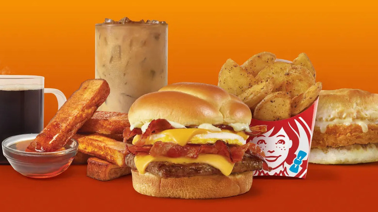 Variety of Wendy's breakfast menu items on an orange background