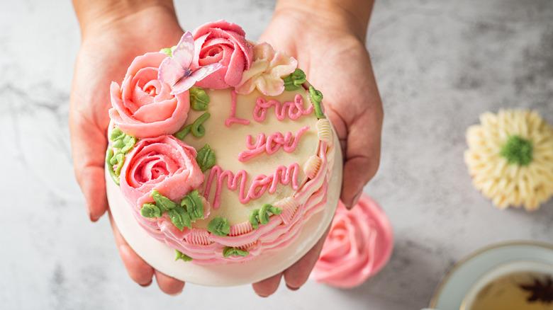 Hand holding Mother's Day cake