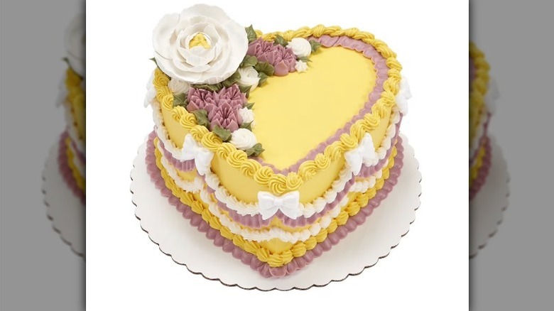 Yellow heart shaped cake on white background