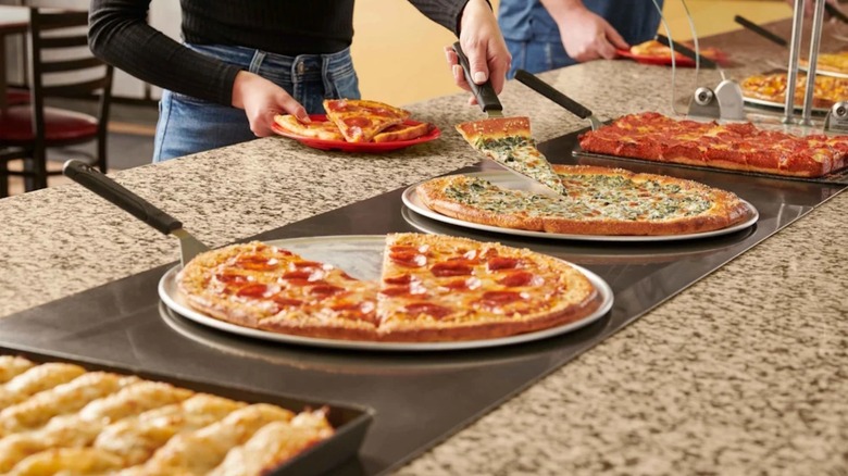 Customers getting pizza from the bar at Cicis Pizza