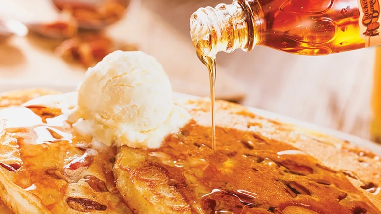 Cracker Barrel maple syrup being poured on pancakes
