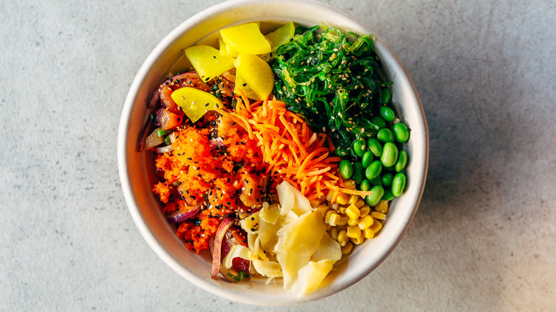 A top-down view of a white bowl of poke