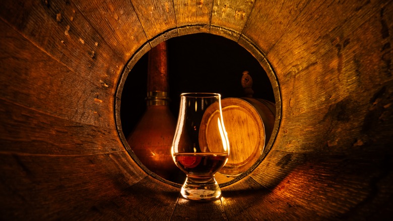 glass of whiskey inside barrel