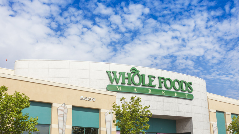 A storefront of Whole Foods Market on a sunny day with trees out front