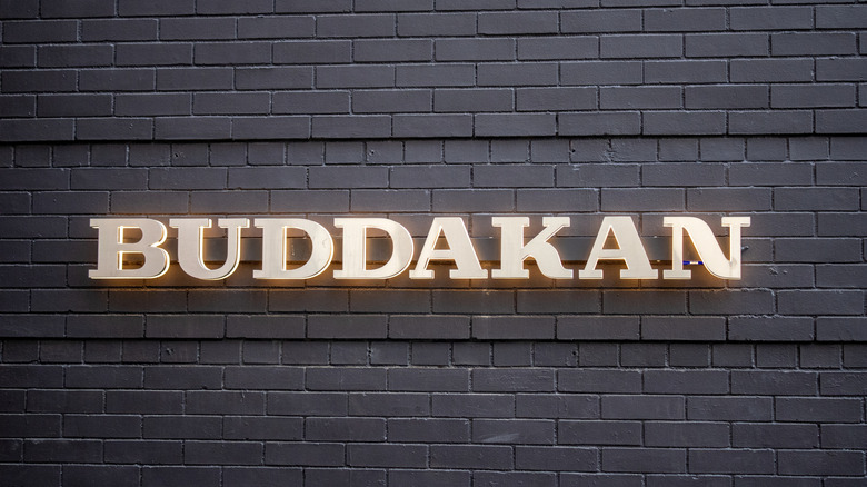 The exterior sign for Buddakan against a brick wall
