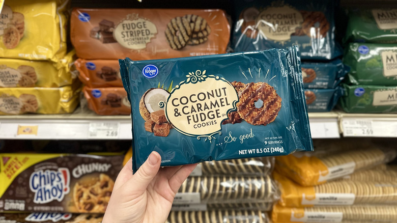 Hand holding a package of Coconut & Caramel Fudge Cookies