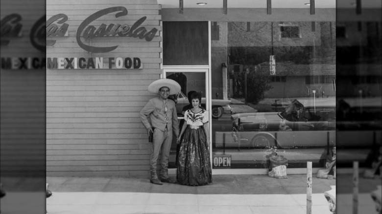 A vintage picture of the exterior of Las Casuelas, with original owners Mary and Florencio "Del" Delgado standing outside