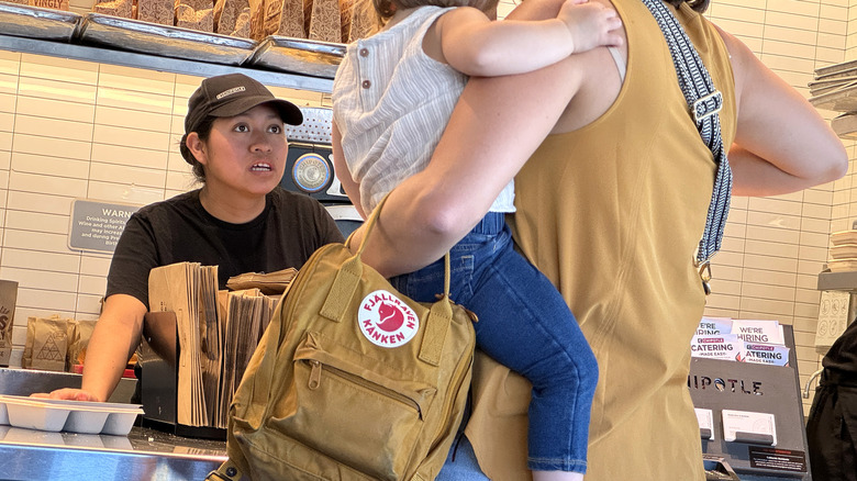 A Chipotle employee looking upset while talking to a customer