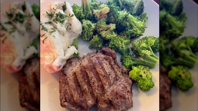 An Applebee's steak on a white plate with broccoli and potatoes
