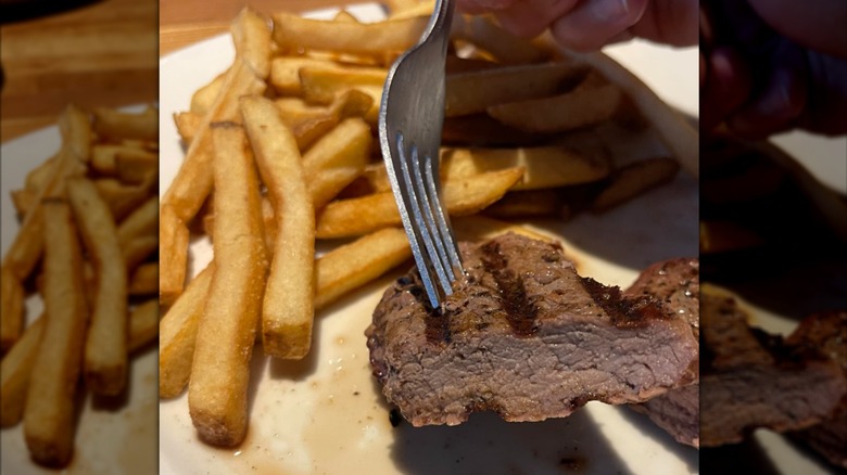 A sliced piece of steak with french fries at Cheddar's Scratch Kitchen