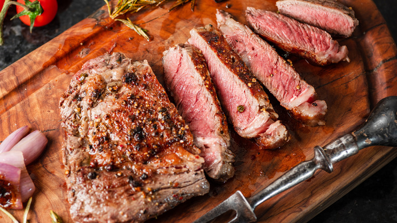 Sliced ribeye steak on a cutting board