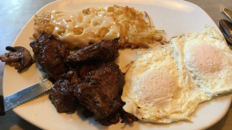Perkins Restaurant and Bakery steak medallions, eggs, and hashbrowns on a white plate