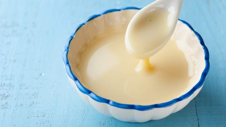 Bowl of condensed milk with a spoon coming out of it