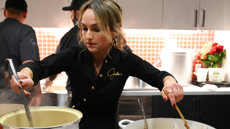 Giada cooking with both hands in kitchen