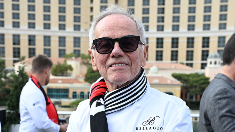 Wolfgang Puck smiling outside the Bellagio Hotel in Las Vegas.
