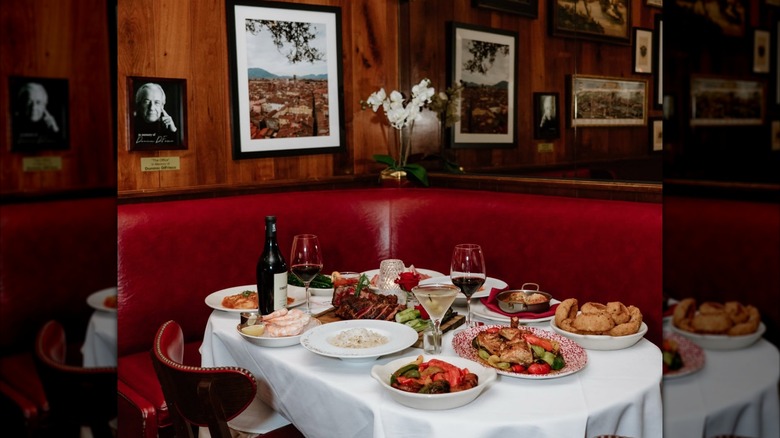Frank Sinatra's favorite booth at Gene & Georgetti with a variety of menu items and wine on the table