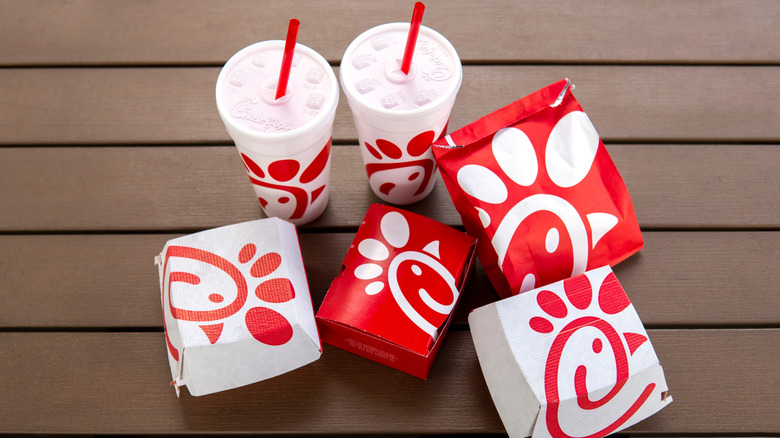 An assortment of Chick-fil-A drink cups and takeout boxes