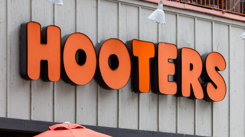 Hooters logo in orange text on a brown wall