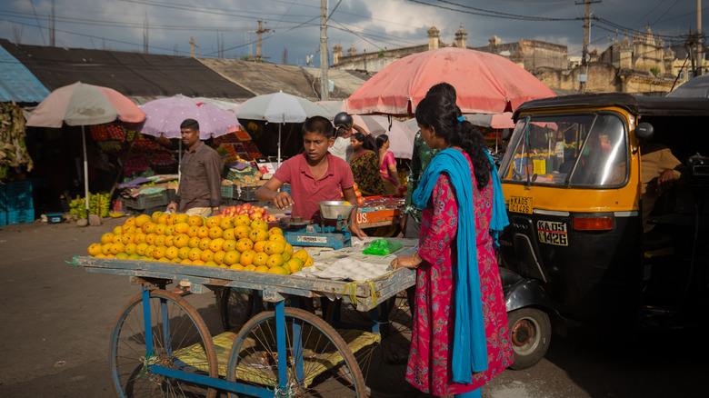 A boy in India selling mangoes from a cart