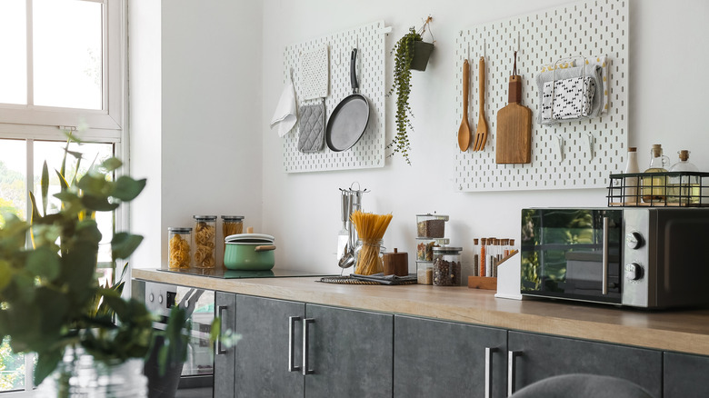 Organized kitchen counters with hanging hooks and stacked dried goods