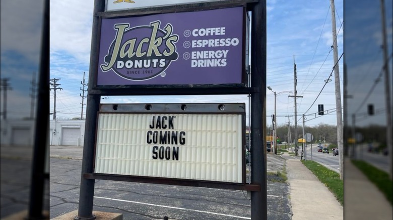 A sign for Jack's Donuts advertising coffee, espresso, and energy drinks. A lettered sign below says "Jack' Coming Soon"