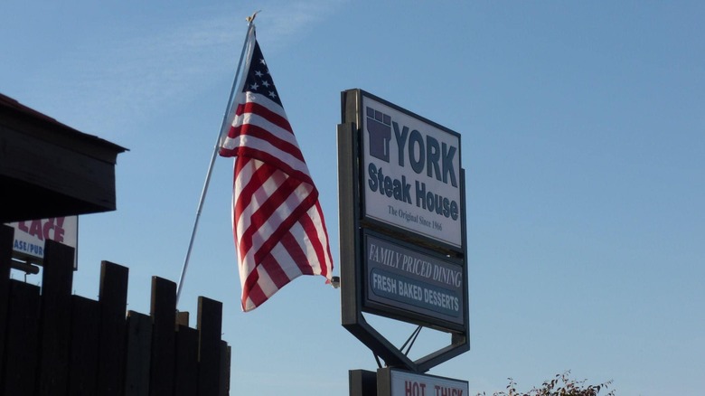 Exterior pillar sign for York Steak House featuring a castle logo