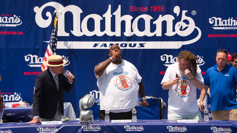 competitors and host at the Nathan's hot dog eating contest