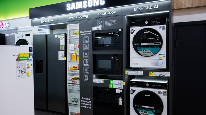 A display of Samsung's home appliances, including a refrigerator, oven, and washing machines, at a store.