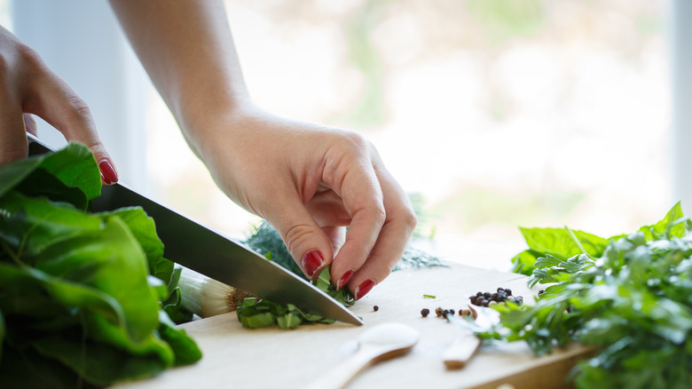 hand chopping basil