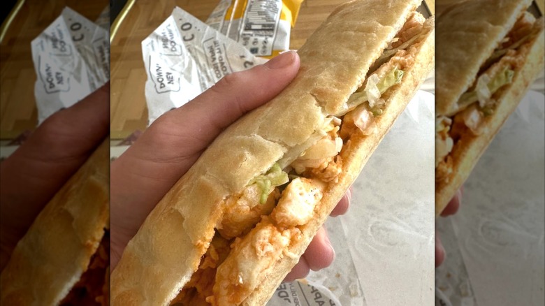 A hand holding a Cosi sandwich