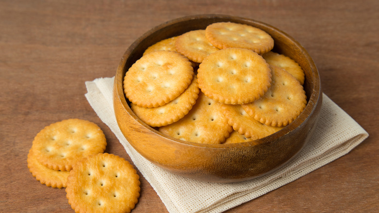 A bowl of Ritz crackers on a wooden table