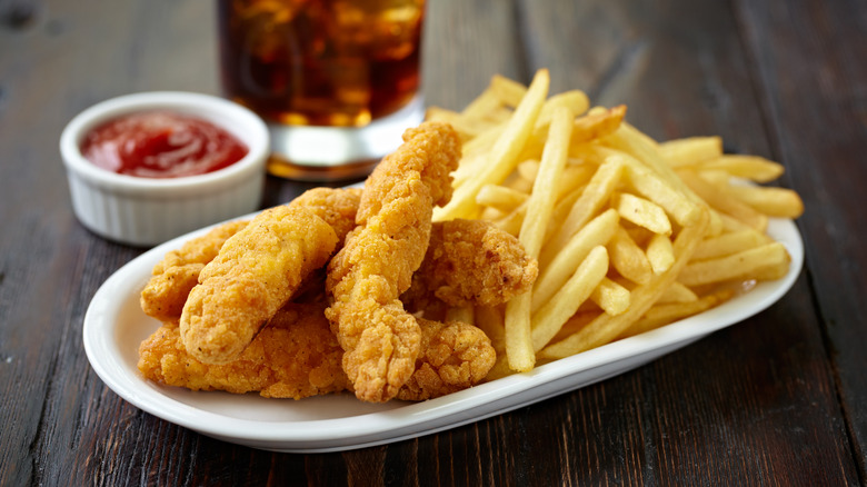 Plate of chicken fingers and fries with ketchup