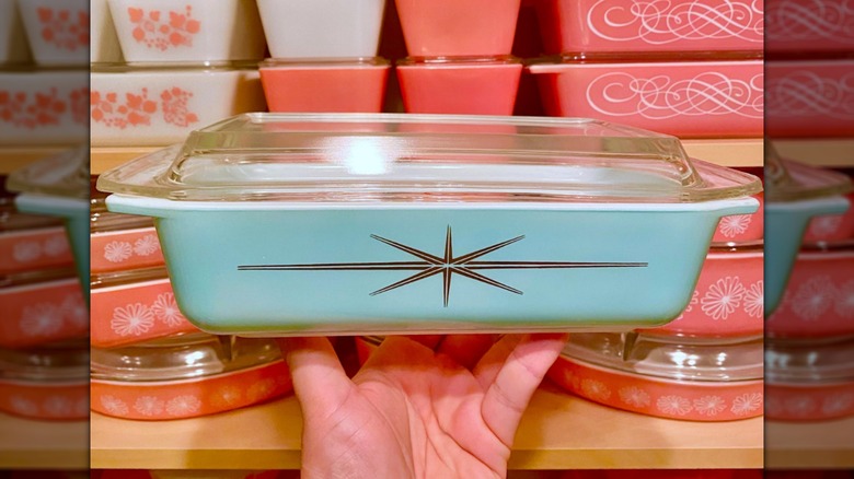 Person holding a Cinderella turquoise atomic starburst Pyrex dish