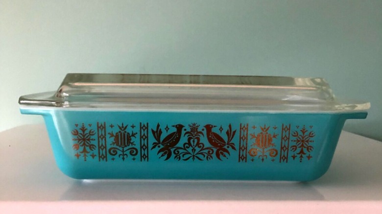 Pyrex casserole dish with turquoise backgound and golden birds and scrollwork on the front