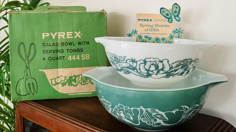 Teal Pyrex Salad Bowl with fruit white fruit design next to green Pyrex box