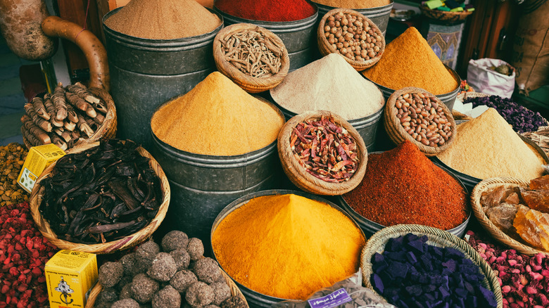 Vibrant colored spices on display at a market.