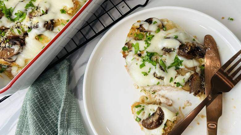 chicken with mushrooms and cheese on a white plate