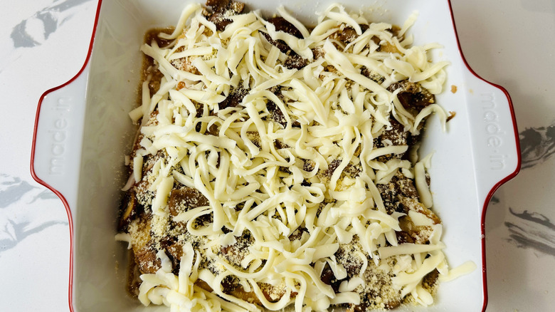 chicken with mushrooms and cheese in a white pan