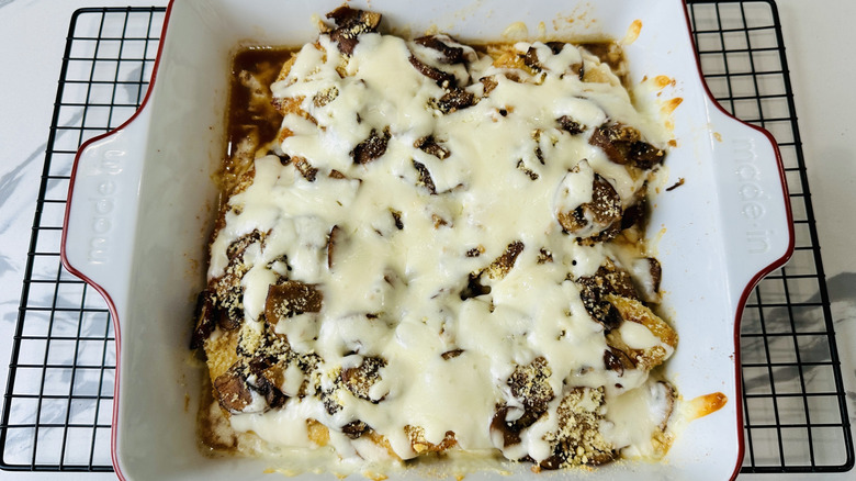 chicken with mushrooms and cheese in a white pan