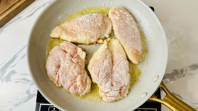 raw chicken breasts in a frying pan