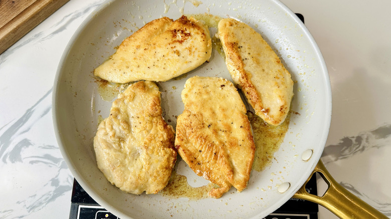 cooked chicken breasts in a frying pan