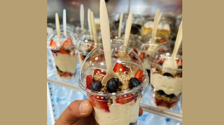 Hand holding a parfait with a selection of parfaits in the background