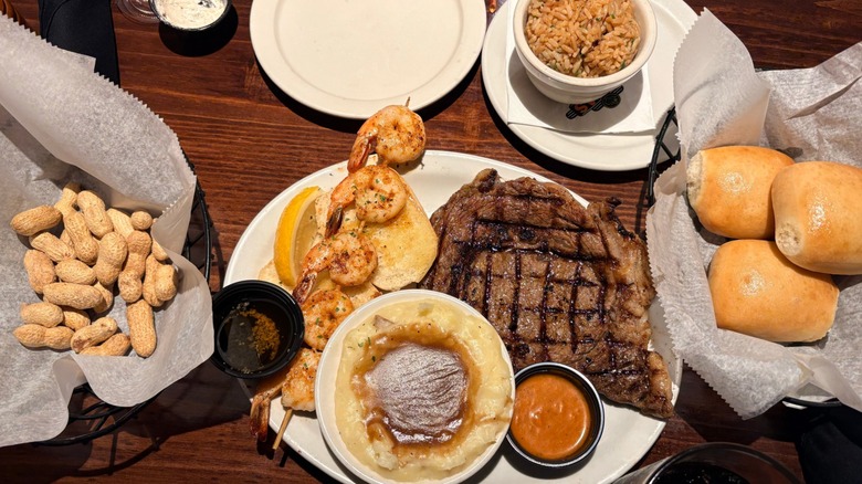 A steak dinner from Texas Roadhouse with several side dishes.