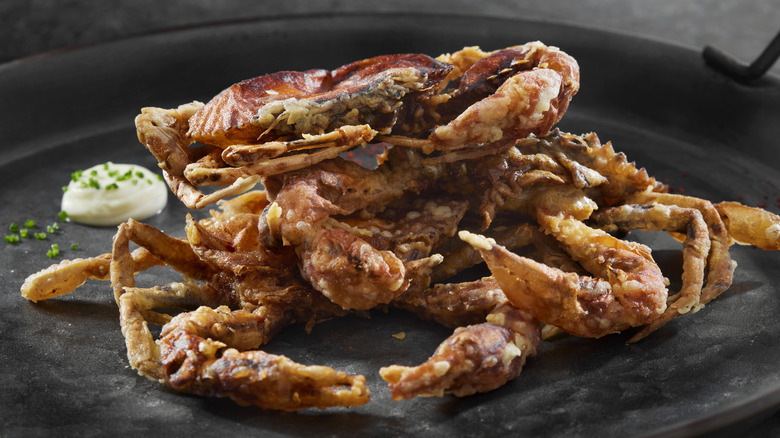 Cooked soft-shell crabs on dark plate