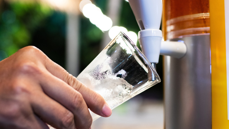 Hand pouring drink from generic beer tower