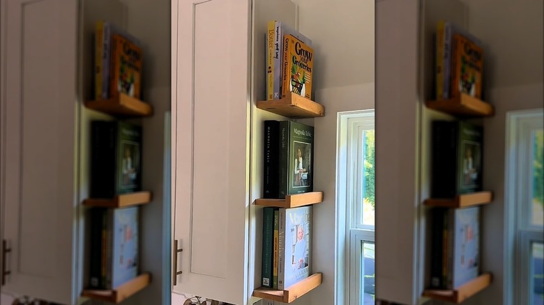 Cookbooks displayed on floating shelves in kitchen