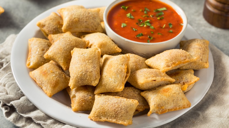 pizza rolls served on plate with bowl of marinara