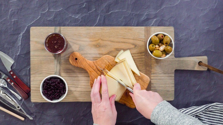 Person making a charcuterie board