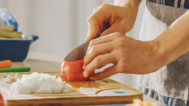 Person slicing tomatoes
