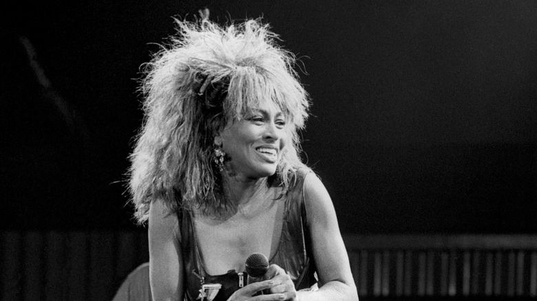 Tina Turner smiling on stage during her 1990 